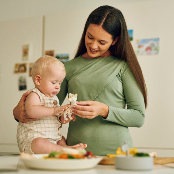 Майка с бебе в кухнята си играе с популярния жираф - безгрижни моменти без притеснения за алергии