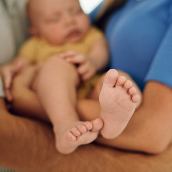 Новородено бебе, спящо в ръцете на родителите си