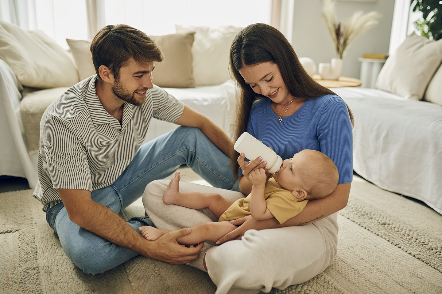 Бебето се храни с шише в ръцете на родителите