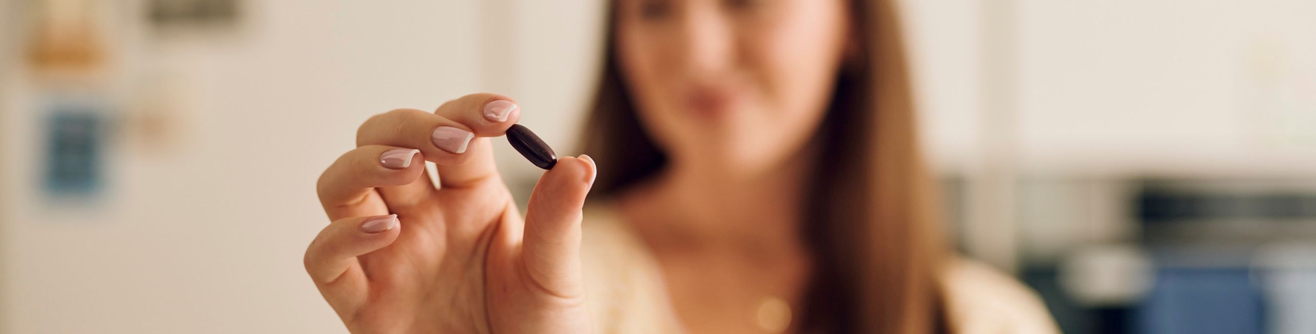 Жена, държаща капсула Novalac prenatal с железни микрокапсули Lipofer