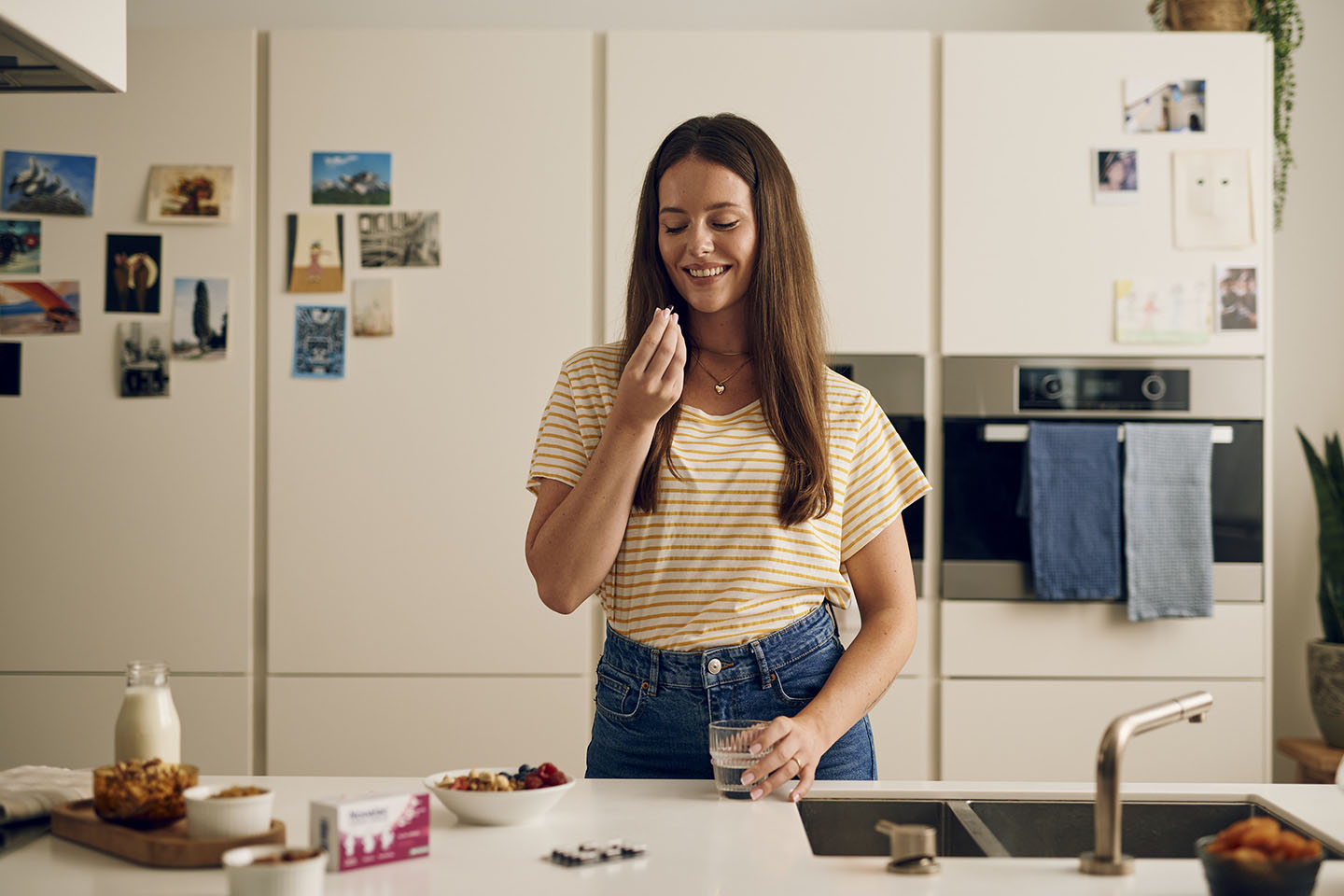 Бременна жена преди прием на пренатални капсули Novalac със закуска и чаша вода.