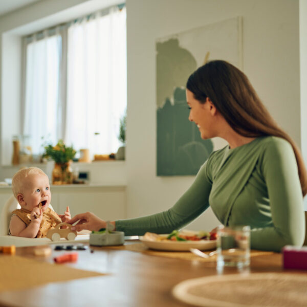 Бебе и майка на масата по време на хранене.