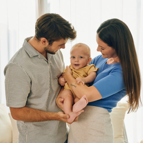 Родители с бебе на ръце – щастлив момент у дома.