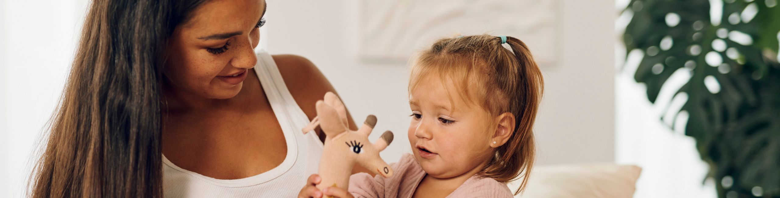 Бременна майка и дете си играят с жираф