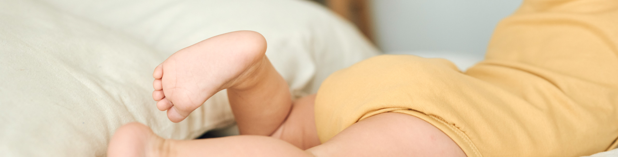 Бебето лежи на леглото.