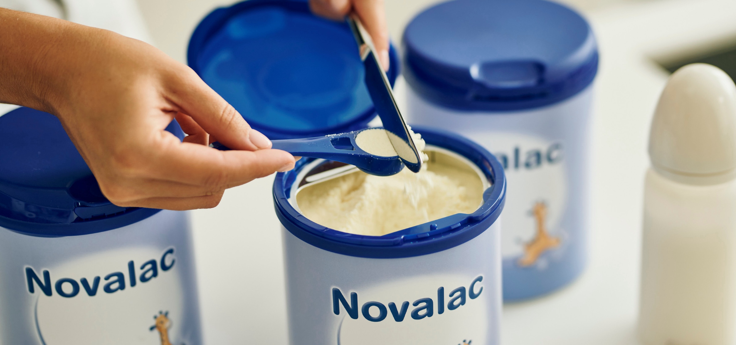 Майка отмерва порция от заместващата формула Novalac.