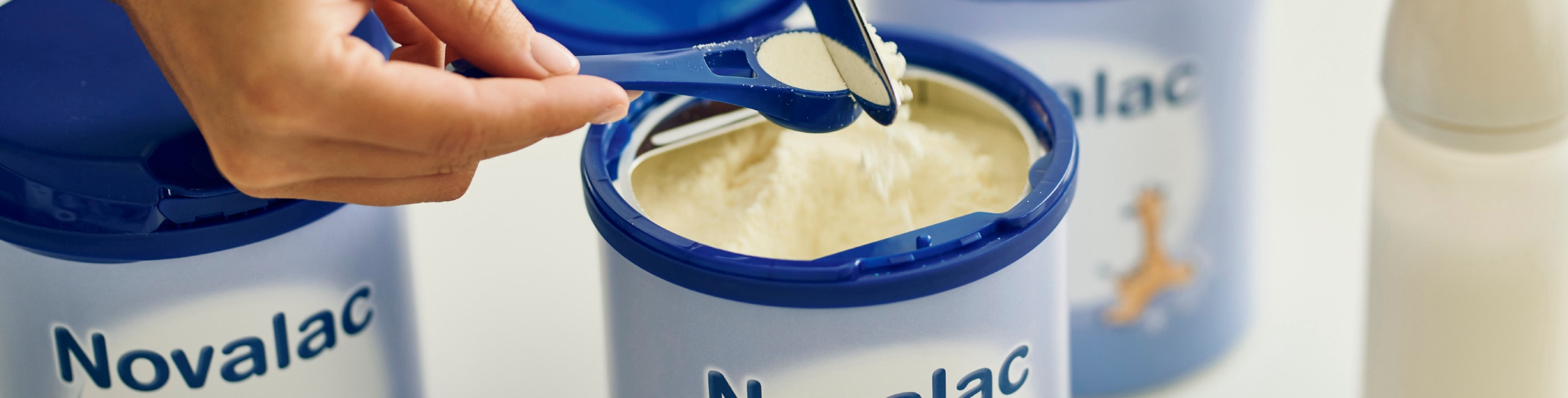 Майка отмерва порция от заместващата формула Novalac.