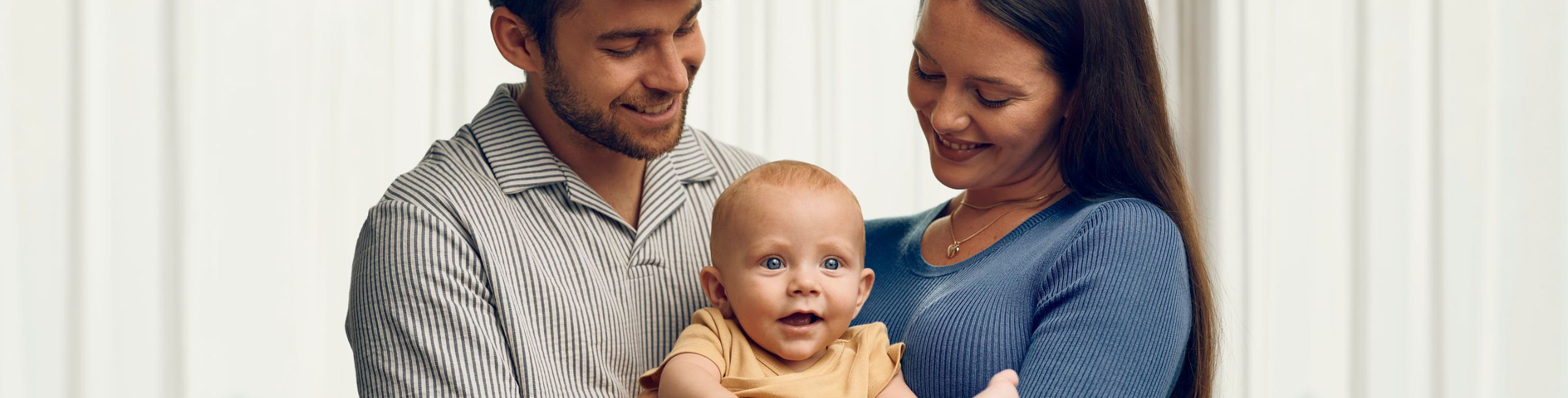 Майка и баща, държащи бебе на ръце, щастливо семейство